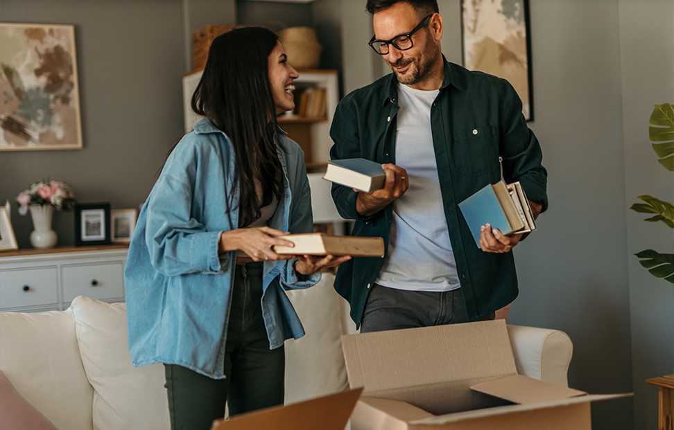 A man and a woman sorting books into boxes.png