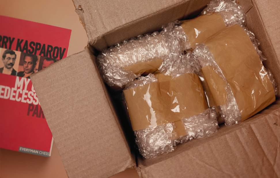 Cardbpard box full of books wrapped in bubble wrap and tape.png