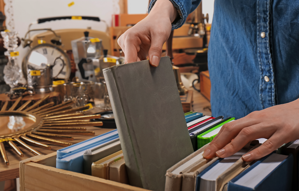 Person looking through old antique books at a market.png