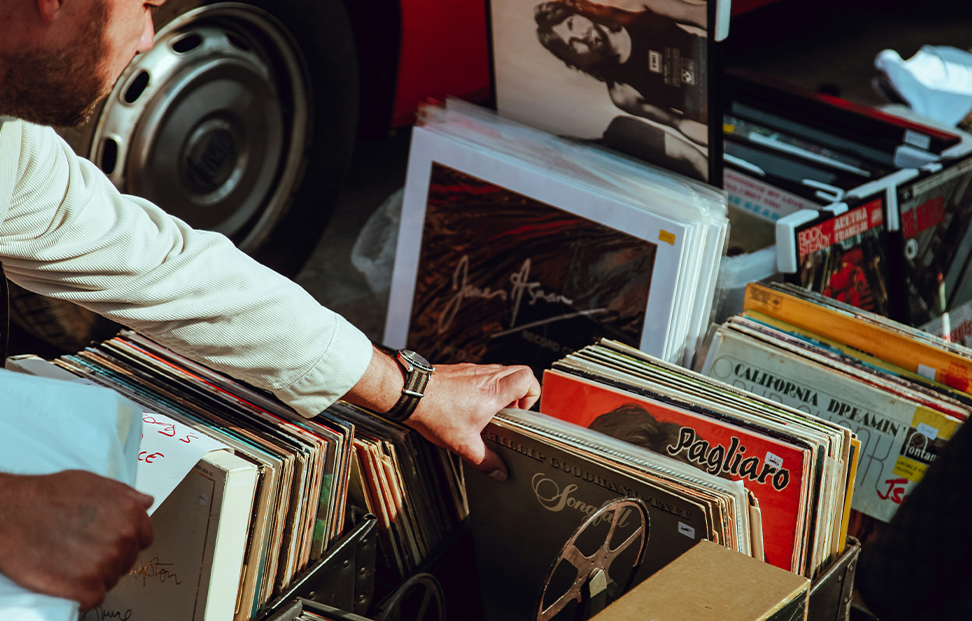 a person looking through several boxes of old vinyl records.png