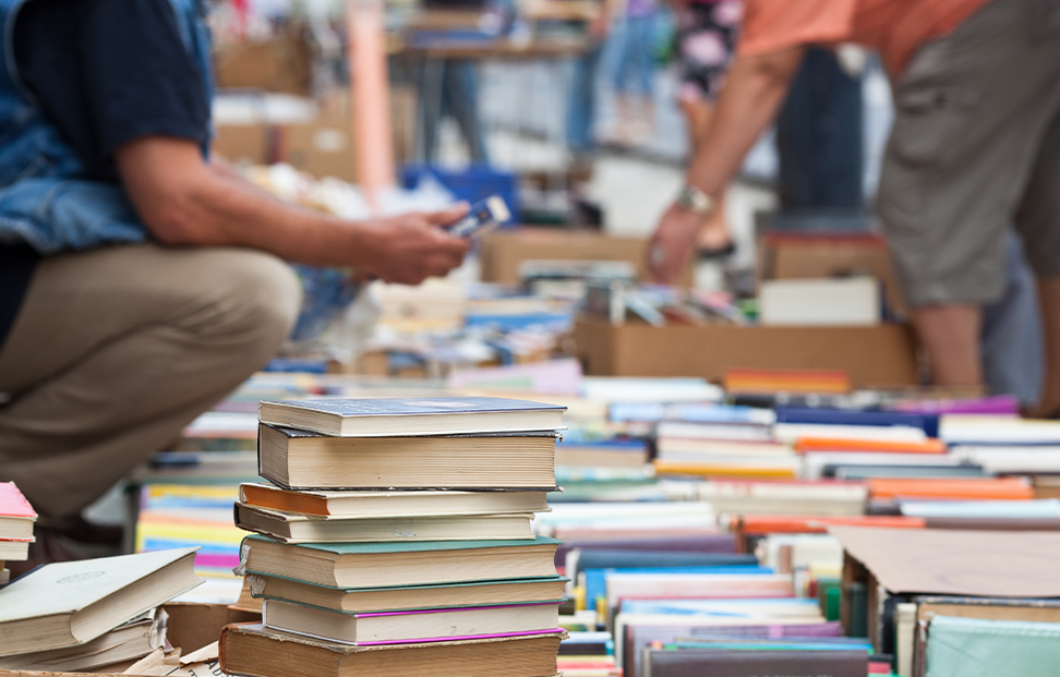 two people searching through a second hand book sale.png